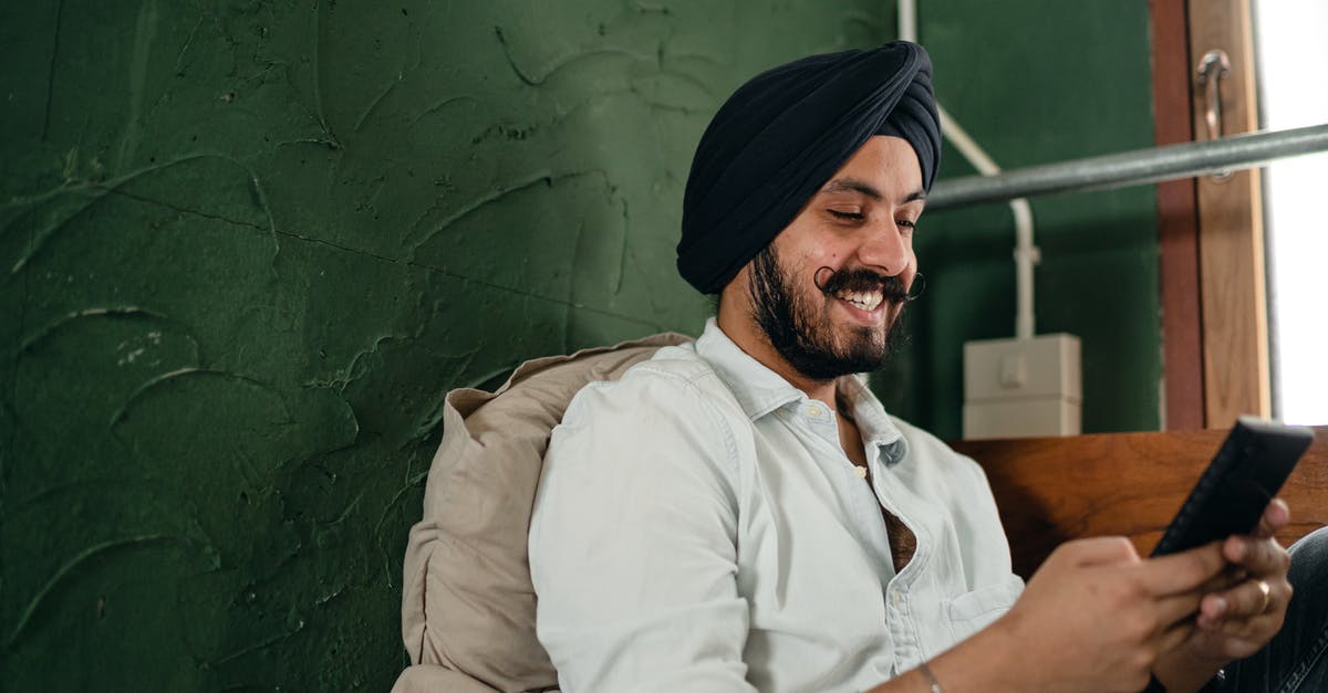 Is there a possibility to preserve an unused Indian mobile number for a period of time? - Happy male of Indian descent smiling while messaging on cellphone Is there a possibility to preserve an unused Indian mobile number for a period of time? - Happy male of Indian descent smiling while messaging on cellphone