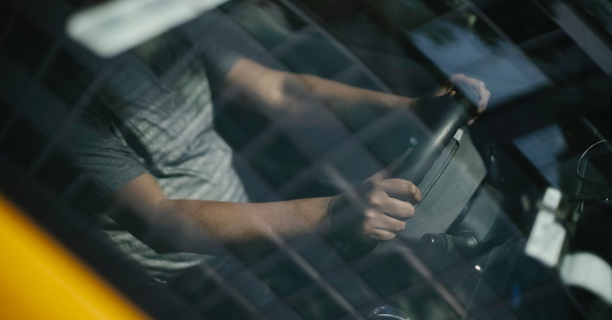 Is there a "safest" route through Pakistan (from China to Iran)? - Through glass of windshield of ethnic crop male driver in cab while working in city