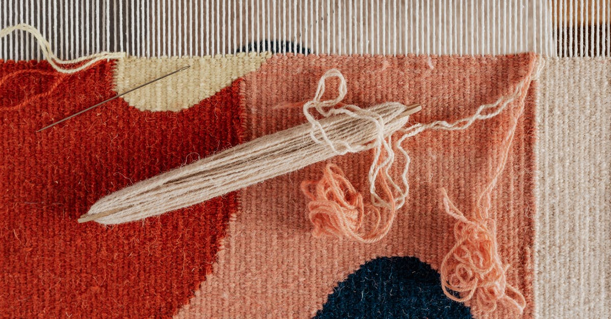 Is there a tool for planning "nested" round trips? - From above of shuttle and needle placed on part of handmade carpet with circle pattern on loom frame during weaving process