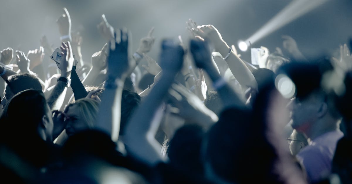 Is there an active nightlife in Seoul on weekdays? - Thrilled people raising hands in excitement and cheering during live concert in dark club