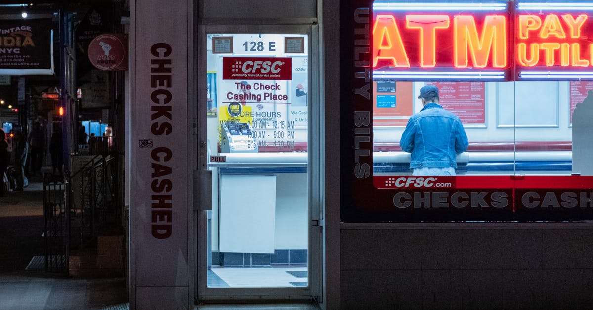 Is there an ATM at or near Vágar Airport? - ATM Booth with Neon Signage