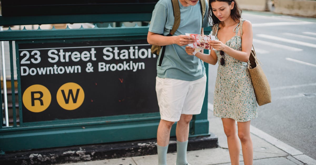 Is there an online community to find travel partners (for mountains, sightseeing etc.)? - Crop anonymous couple searching direction in map while sightseeing together in city center during trip