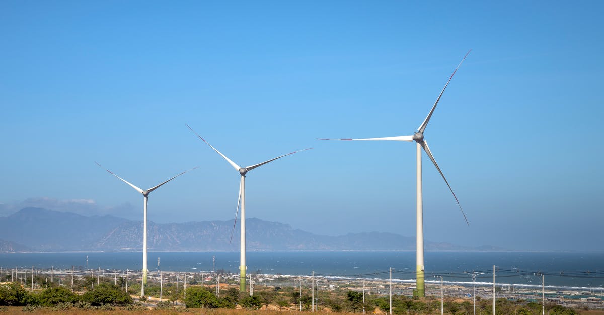 Is there any similar alternative to Zanzibar, in Tanzania? - Rows of wind generators on land with plants against sea and mountain in daylight