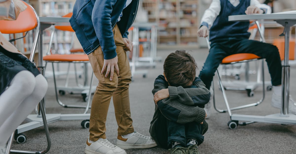 Is there racism in Estonia? - Sad Boy in Gray Sweater Sitting on the Floor