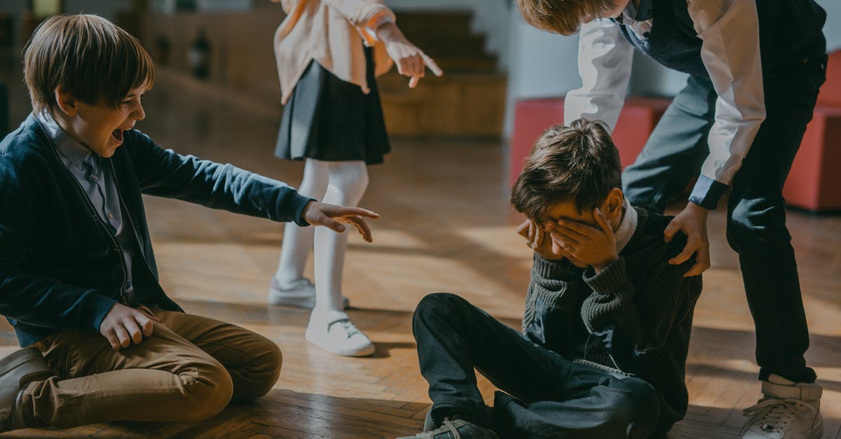 Is there racism in Estonia? - Children Finger Pointing at a Boy Sitting on a Wooden Floor