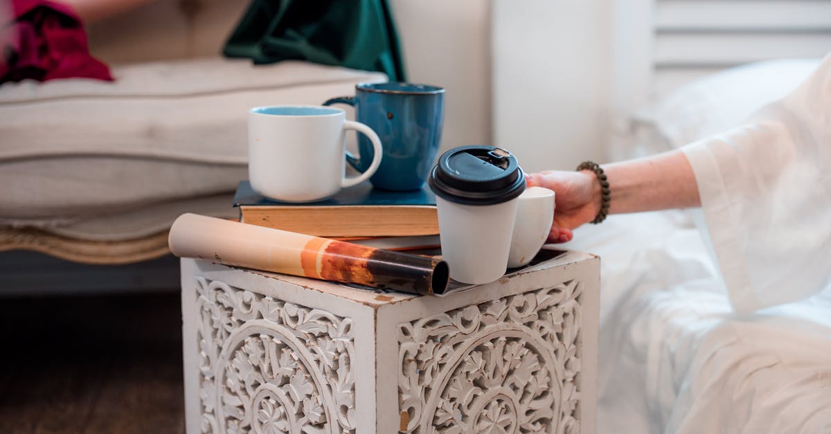 Is there somewhere to buy used Latvian books in Riga? - A Person Putting a Ceramic Cup on the Coffee table