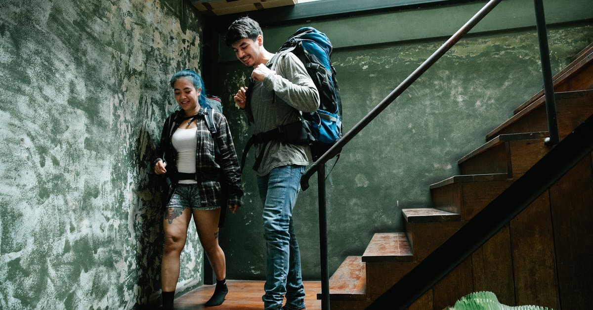 Is this a realistic backpacking trip in Europe? - Man in Black and White Jacket Standing on Brown Wooden Staircase