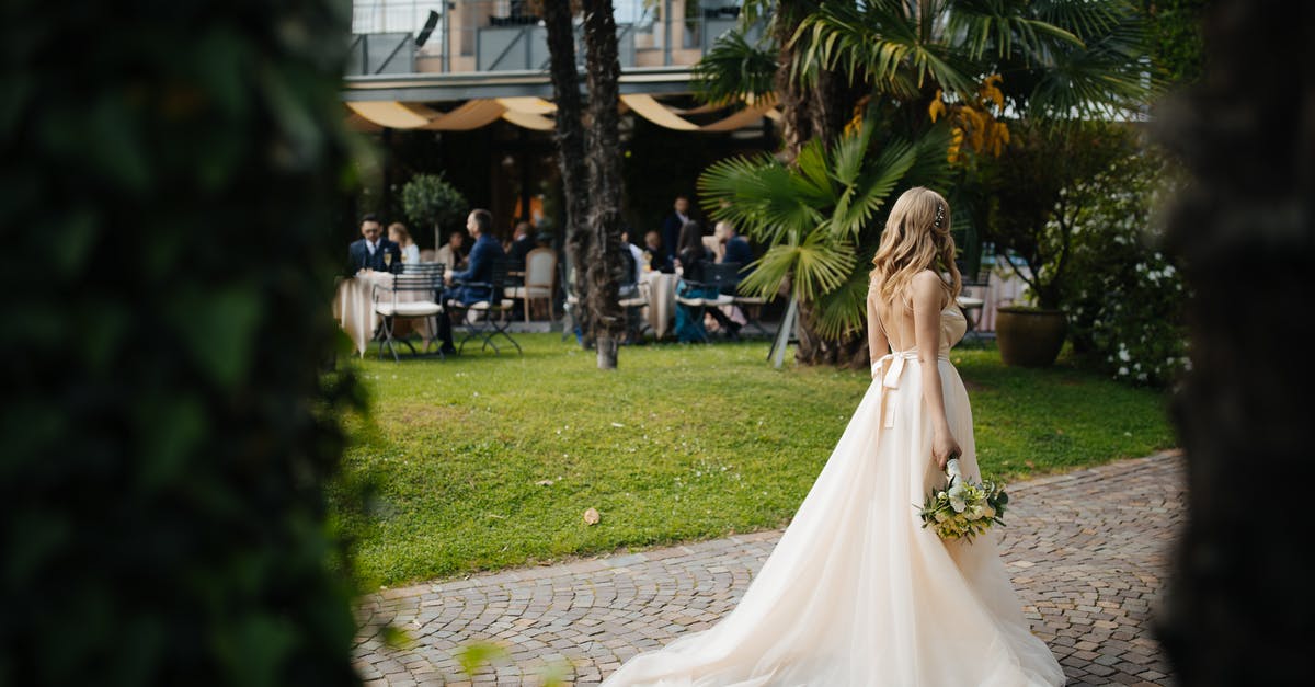 Is Thursday a “party” day in Spain or Germany? - Woman Wearing Wedding Dress and Holding a Bouquet of Flowers Standing on Brick Pathway