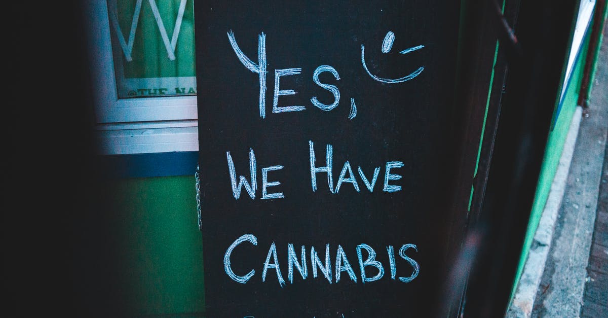 Is weed still legal for tourists in Amsterdam? - Lettering written on black chalkboard with cannabis offer near house on street of city