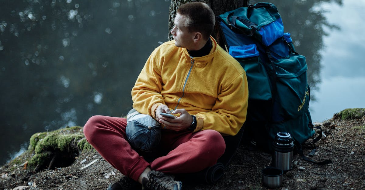 Issues when camping during trek in Georgia? - Man in Yellow Sweater and Red Pants Sitting on Ground