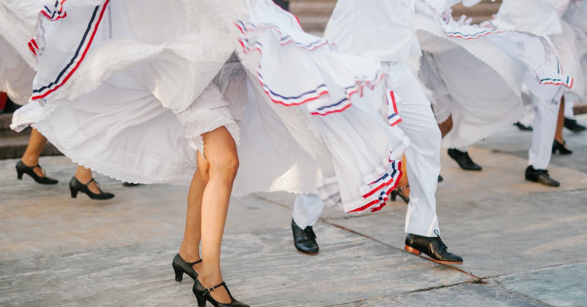 It's allowed to dance (and cultural events) on the Louvre Square? - Crop unrecognizable artists in white costumes dancing on street during festival on sunny day