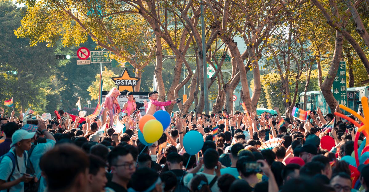 It's allowed to dance (and cultural events) on the Louvre Square? - Crowd of unrecognizable Asian people standing on city street with colorful balloons and watching performance during festival on sunny day