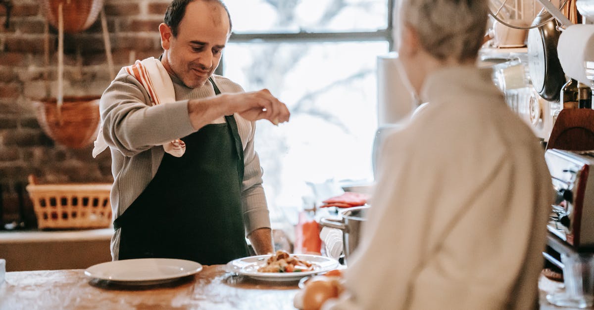 Italian consulate Schengen visa time - Man cooking food on counter in kitchen near woman