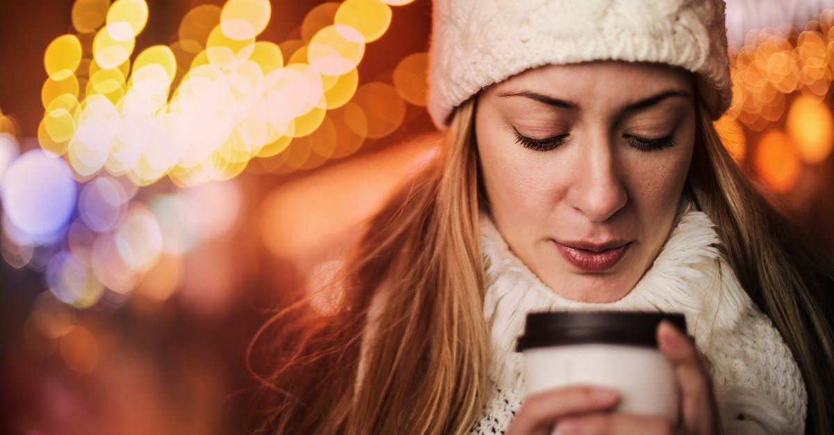 Items to keep warm while out in the cold - Woman with takeaway hot drink on street in cold weather