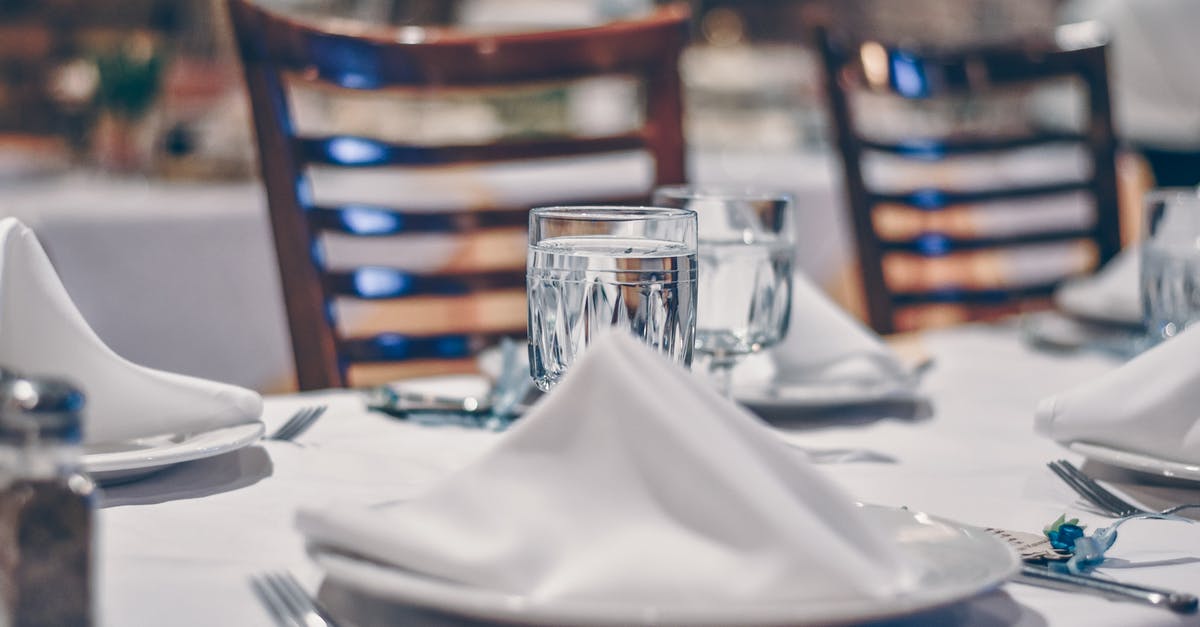 Jain food options in NYC (Wall Street) - Depth of Field Photo of Clear Drinking Glass on White Table Near Plate