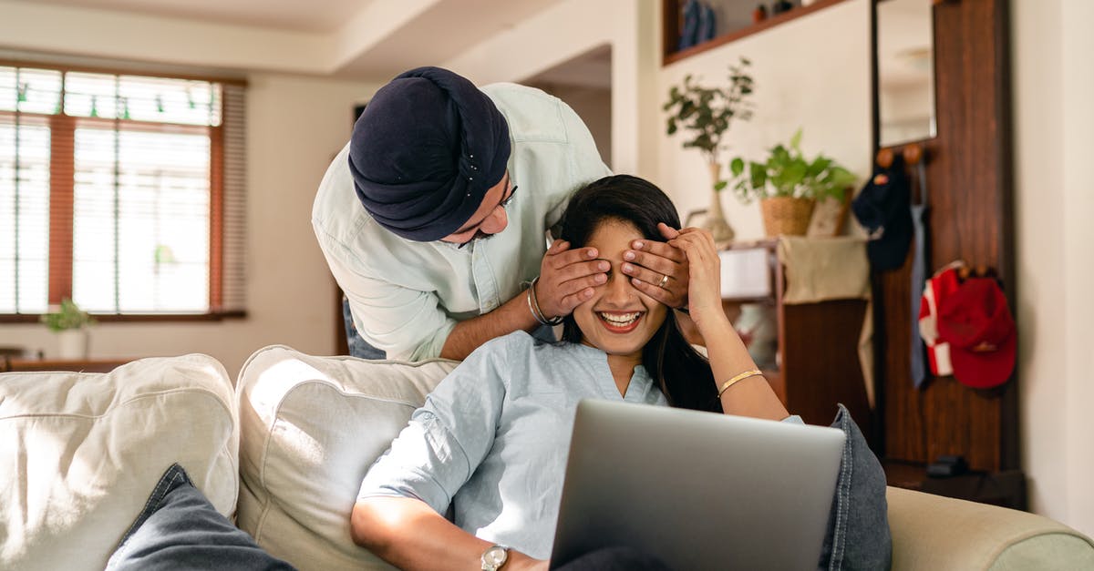 Jamaican citizen, Indian husband; travelling to Jamaica on one-way tickets [closed] - Cheerful ethnic couple with laptop at home