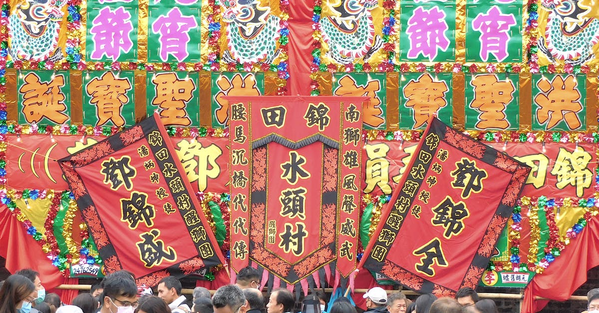 Japanese tourist visa for Chinese national with UK permanent residence - Traditional Chinese festival in front of large colorful signboard with flags