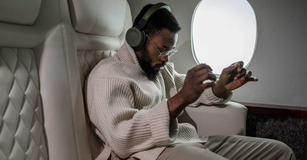 Jet Airways connecting flight [closed] - Man Listening to Music While Inside a Airplane