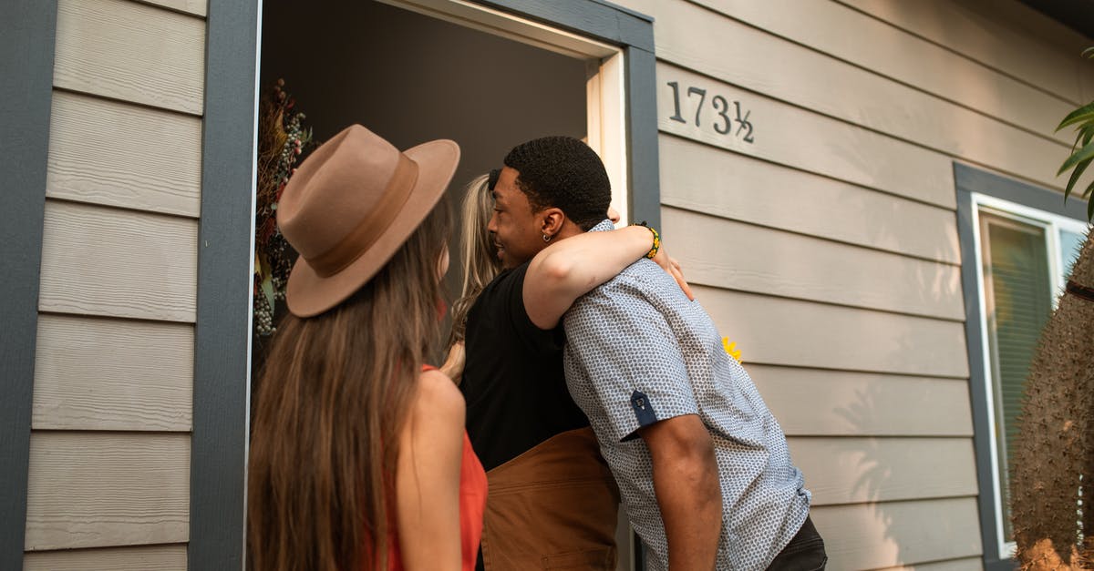 Jewish person visiting American friend in Qatar - A Person Hugging a Man at the Doorway