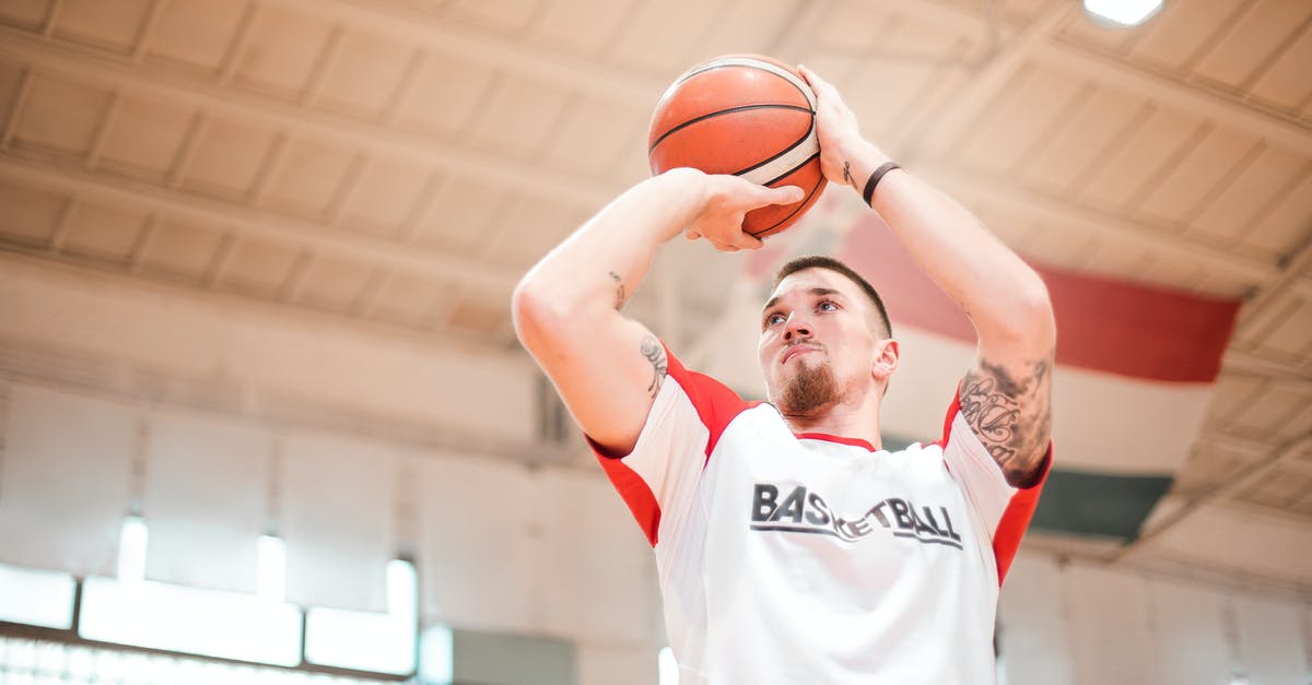 Joining the Mile High Club (MHC) - Can I get into trouble? - From below of concentrated basketball player with tattoos on arms preparing throwing ball to hoop