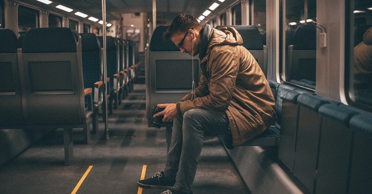 Journey planner for finding intercity train connections in China? - Young stylish guy checking photos on camera while riding on train