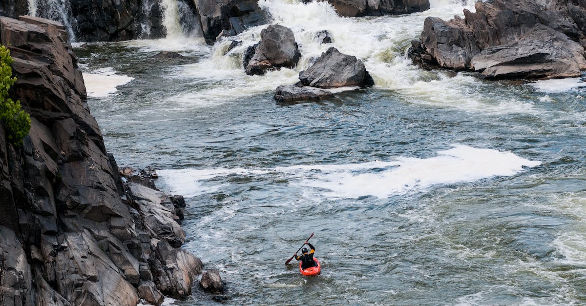 Kayak options in Patagonia - Person in Red and Black Wet Suit Riding on Orange Kayak on Blue Ocean Water during