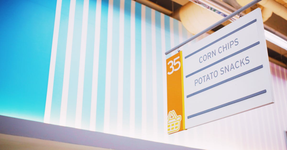 Kosher food on British Airways Buy on Board - From below of signboard with inscription Corn chips Potato snacks hanging under ceiling in contemporary supermarket