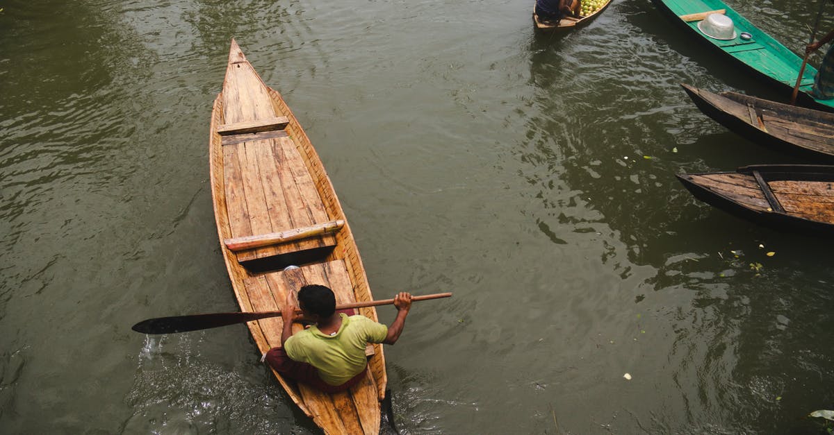 Labor Day Monday - Niagara or DC? [closed] - Ethnic man swimming on canoe along boats in river