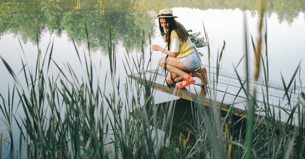 Lake McKenzie turning green? - Woman in White Tank Top Sitting on Wooden Dock