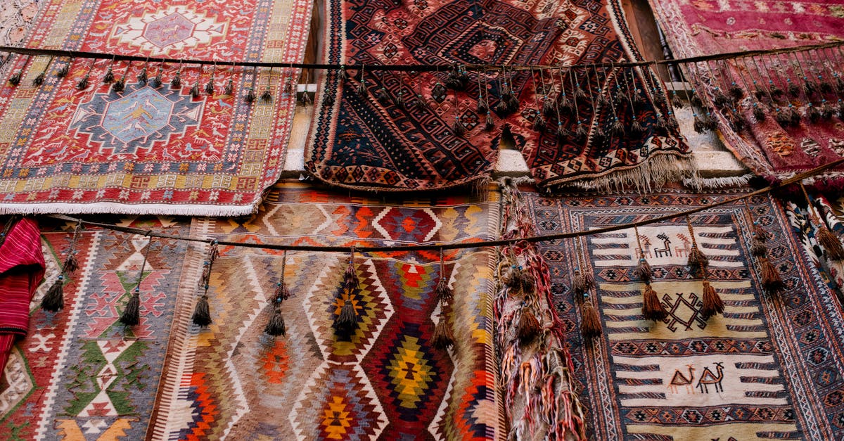 Land-based travel in the Middle East - Colorful handmade weaved with oriental ornament middle east rugs hanging in open market