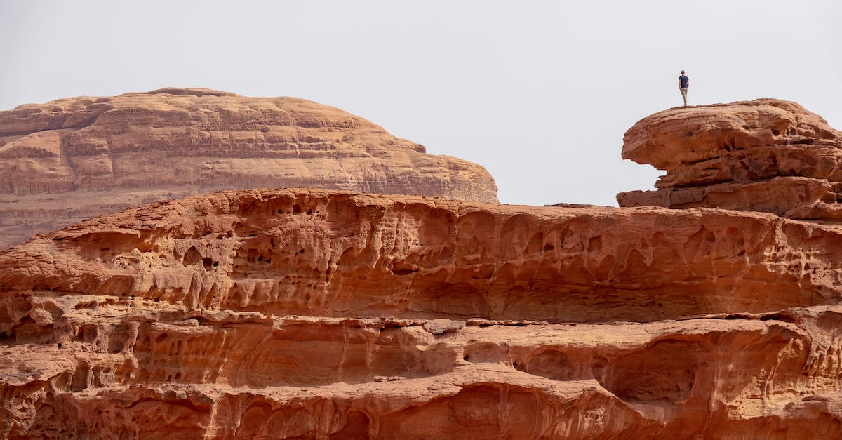 Land-based travel in the Middle East - Person Standing on Brown Rock Formation