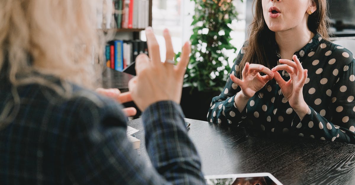 Language to communicate in tourist places in Bratislava? English is sufficient? - Young female friends communicating using sign language in library