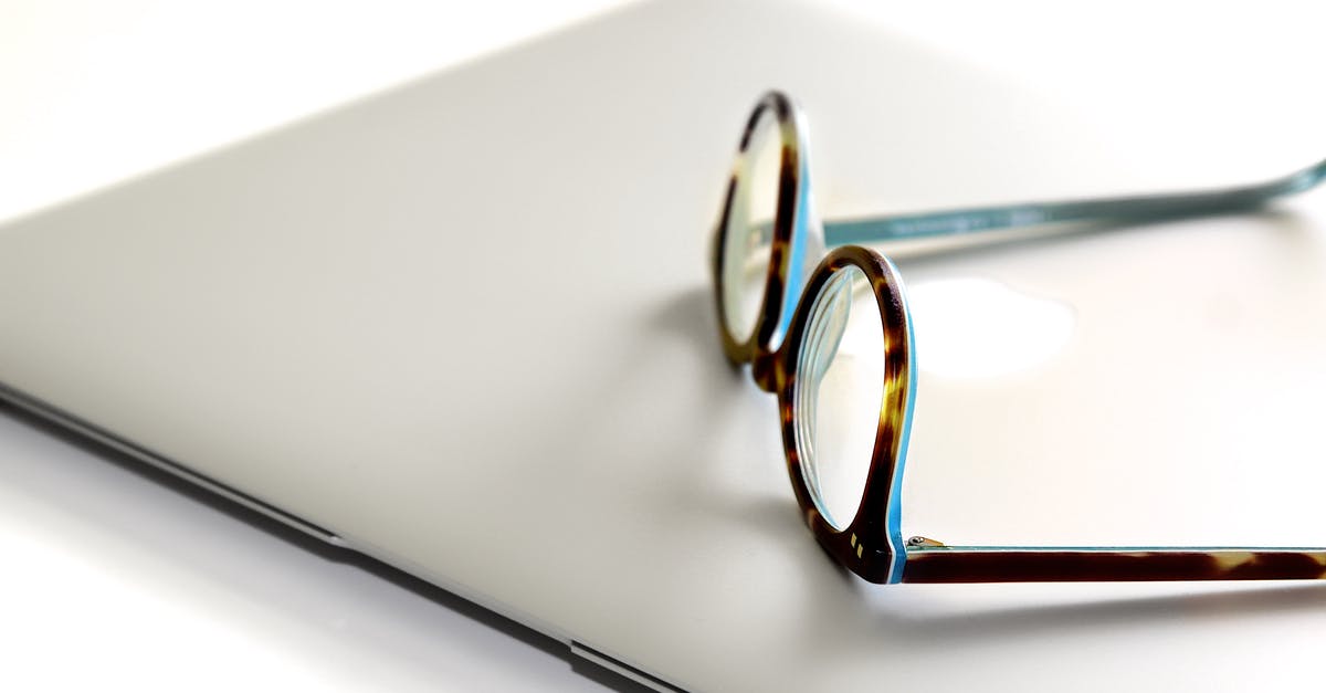 Laptop and tablet restrictions within US air travel - Black and Blue Framed Eyeglasses on Silver Laptop