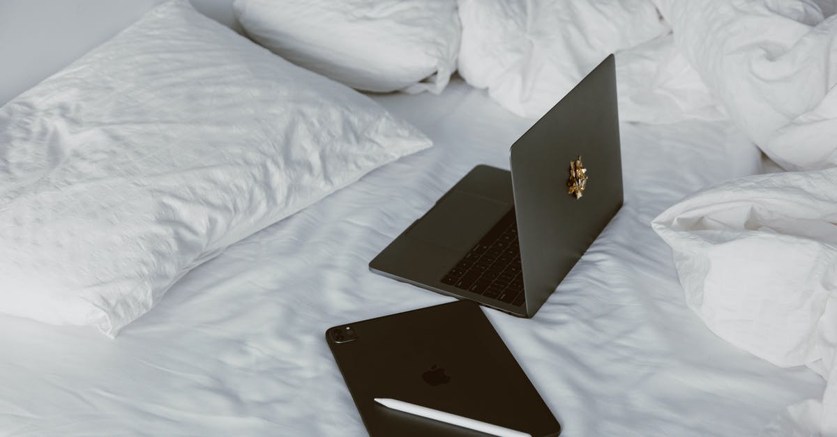 Laptop and tablet restrictions within US air travel - Black Macbook on White Bed