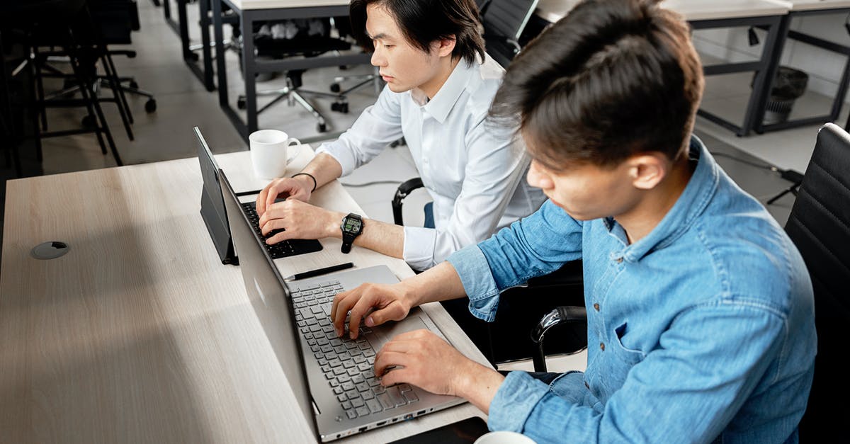 Laptop and tablet restrictions within US air travel - Man in Blue Dress Shirt Using Macbook Pro