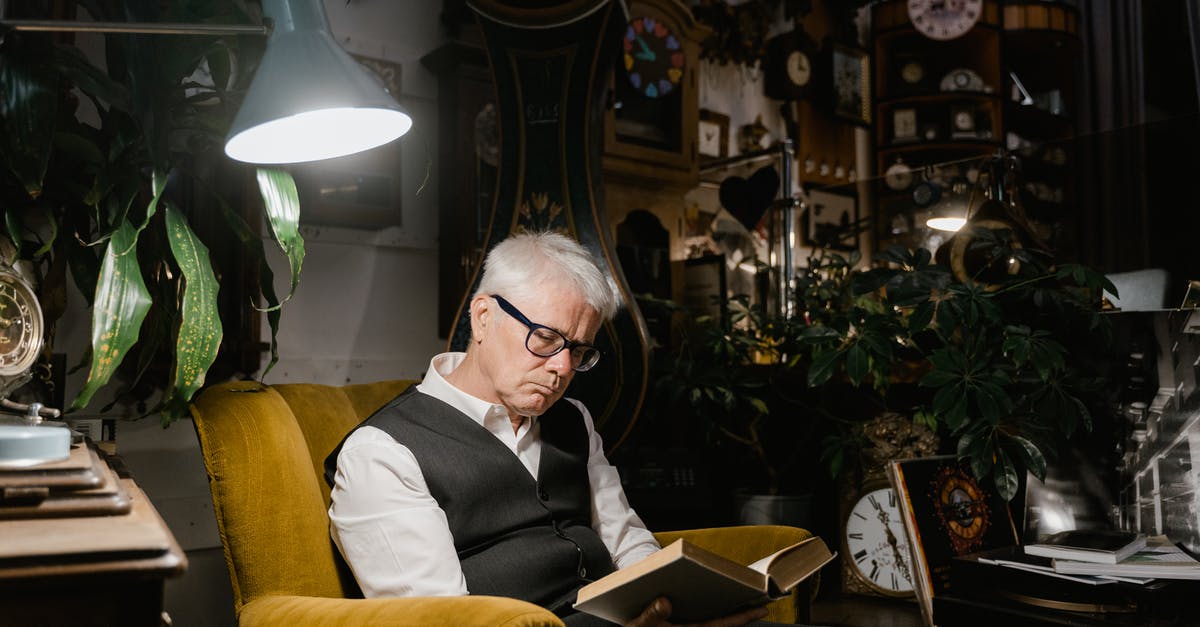 Last minute hotel deals - Man in Black Suit Jacket Sitting on Yellow Chair