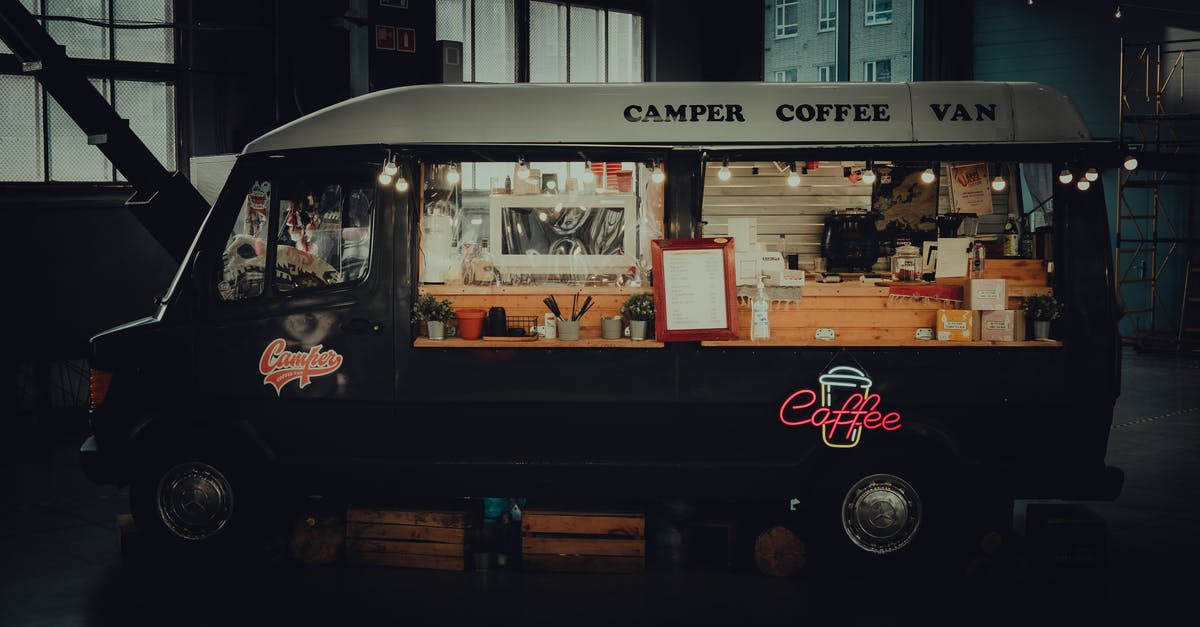 Late evening public transport in Nice - Contemporary black coffee van with inscriptions and sparkling signboard in late dark evening