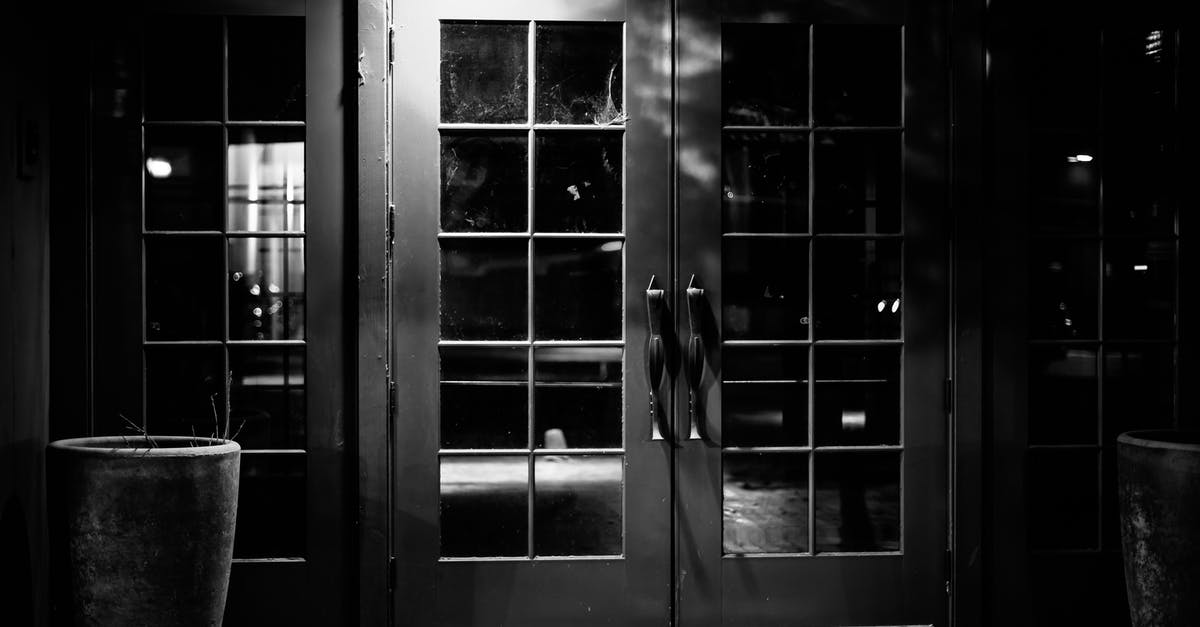 Late night public transit from Tel Aviv airport? - Black and white of entrance with closed glass door of empty bar at night