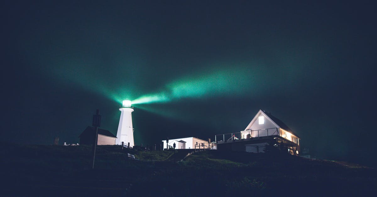 Late night travel on a Sunday in Barcelona - Green lighthouse in dark night on hill