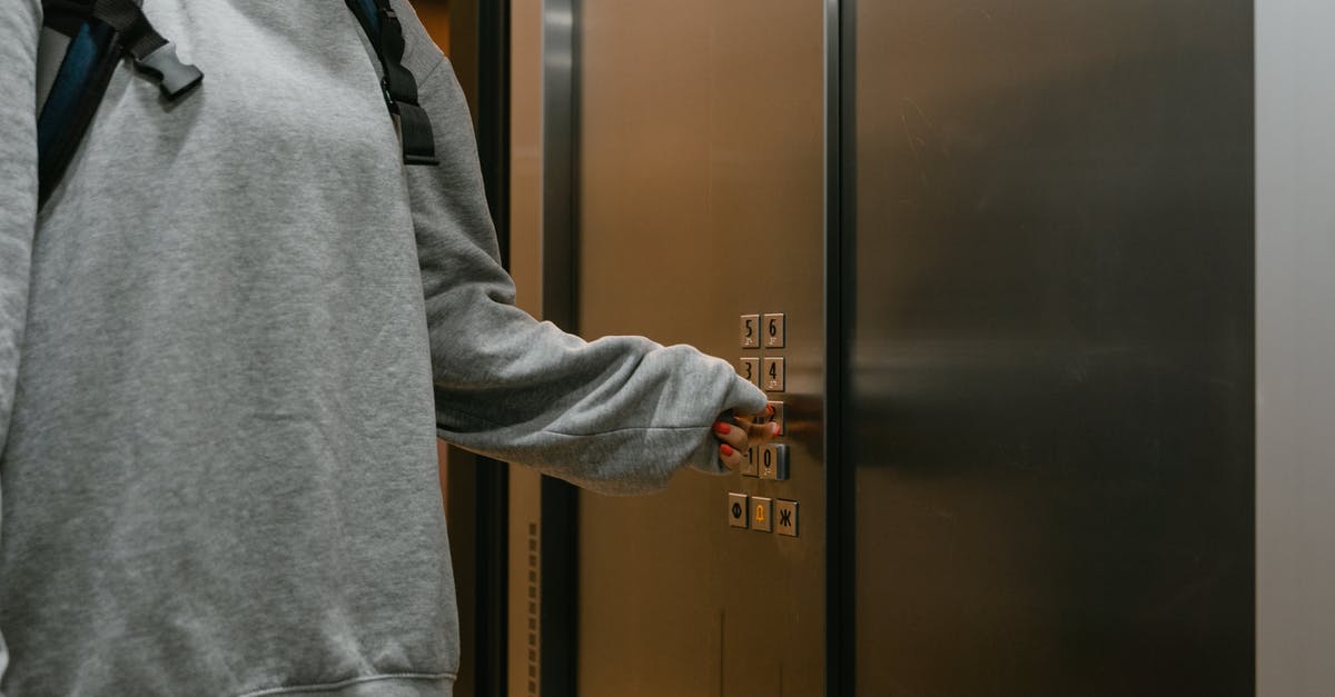 Layover in Warsaw. Will I be quarantined? - Person Pressing the Elevator Button