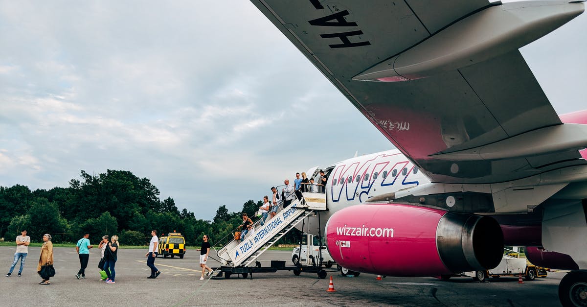 Layovers in Riga Airport RIX: 45 min possible? - People Walking Near Red and White Airplane Under White Clouds