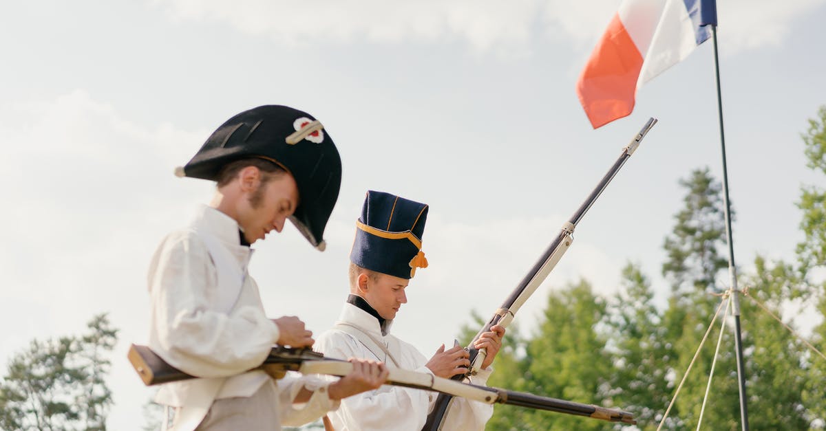 Learning French in France [closed] - Soldiers charging guns near French national flag in nature