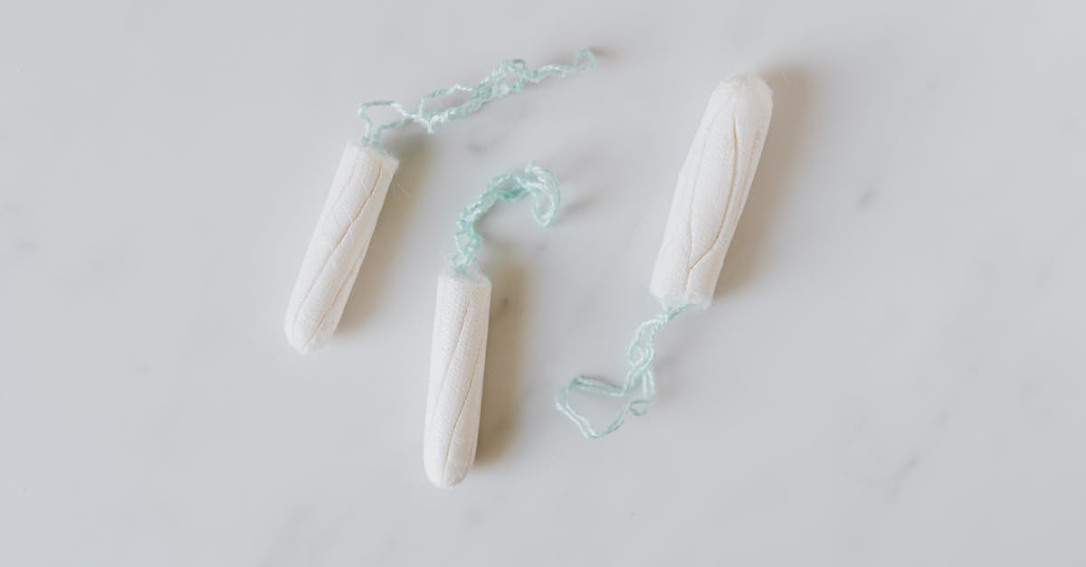 Leave to stay for 6 months cooling period - Top view of three hygienic cotton tampons placed on white marble patterned surface