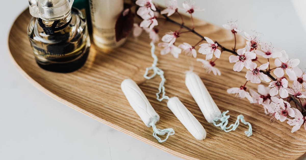 Leaving Singapore the day after visa period ends - Wooden tray with perfume cosmetic products hygienic tampons and flower branch