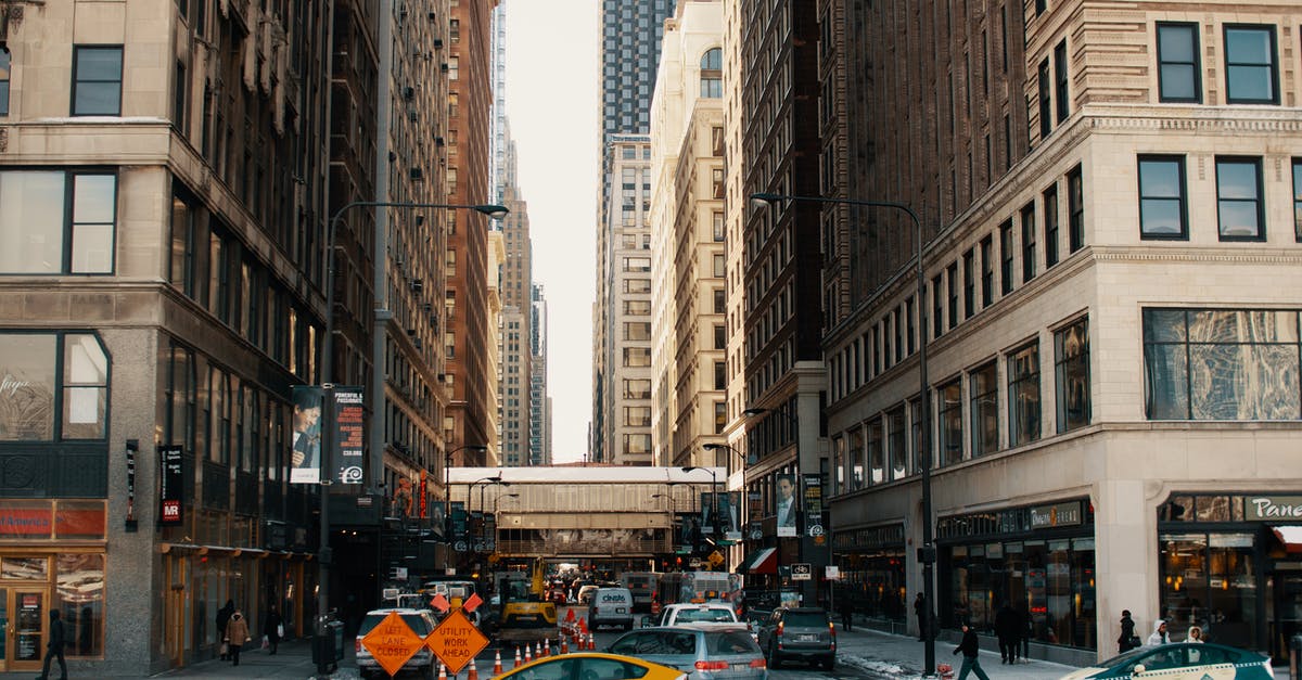 Leaving the Schengen area with a Refugee Travel Document issued by the USA - Cars driving on asphalt road between contemporary skyscrapers and buildings in New York City in daytime