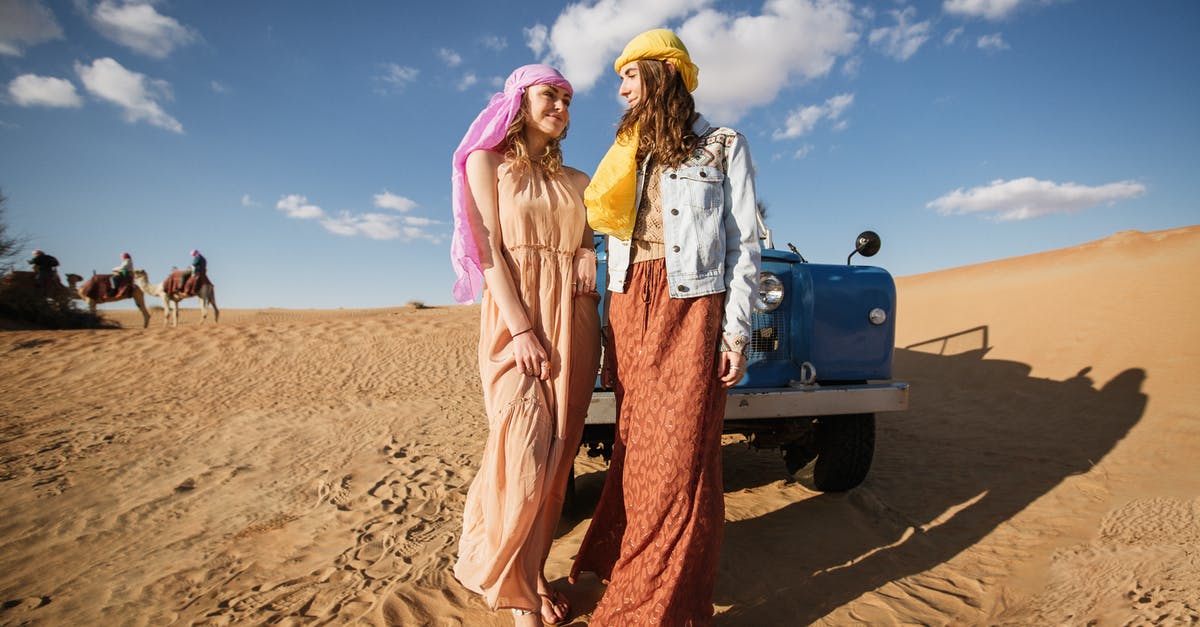 Leisure/single long-visit visa Dubai - Women in Long Dresses Standing Near Blue Vehicle