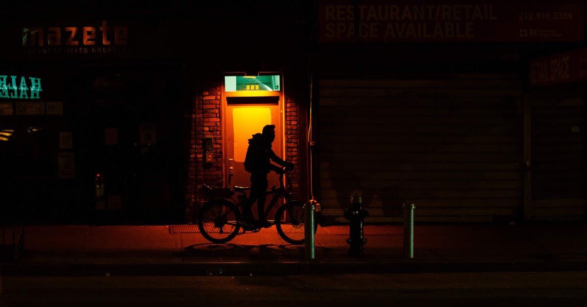 Length of stay in Schengen area - Silhouette of cyclist with bicycle walking on dark sidewalk