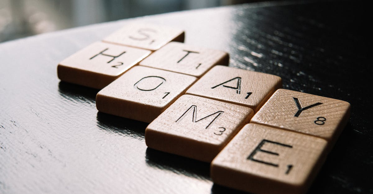 Letter of support - Canada Visa - High angle of scrabble letter tiles arranged on black wooden table in inscription Stay Home in living room