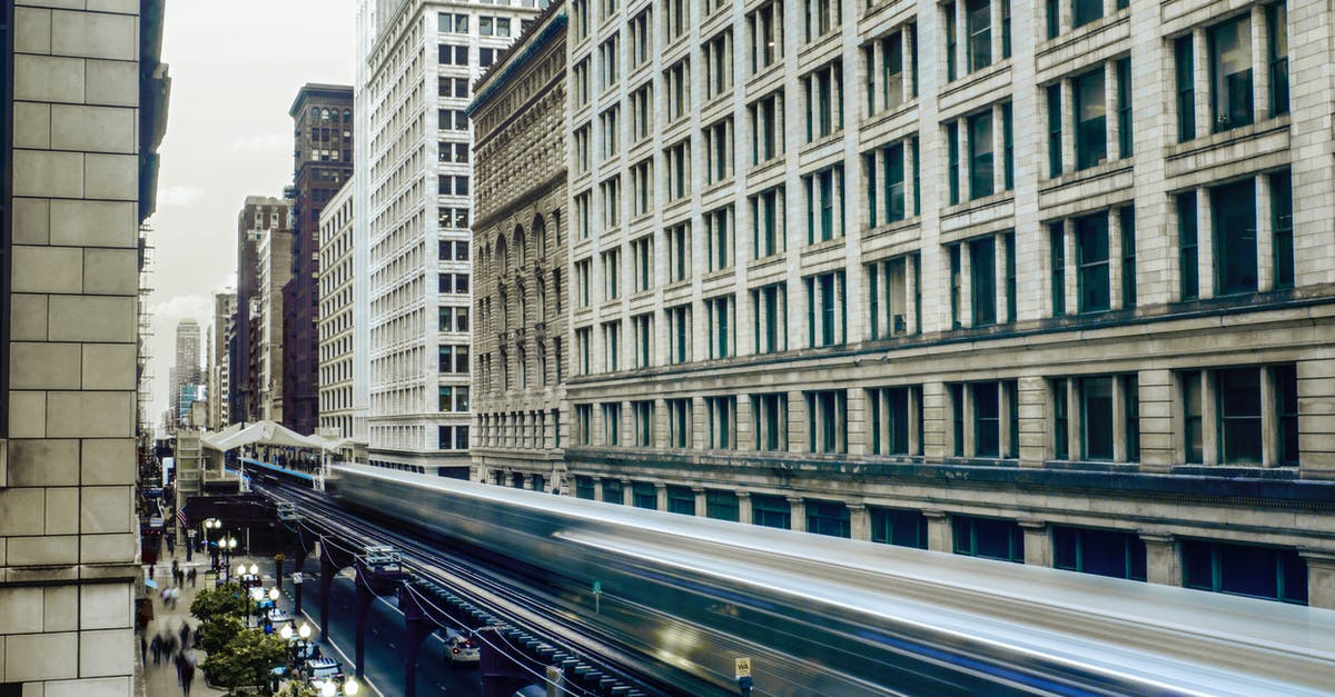 Local transportation from/to ORD Chicago Airport? - Time Lapse Photo of White Train Passing by Buildings