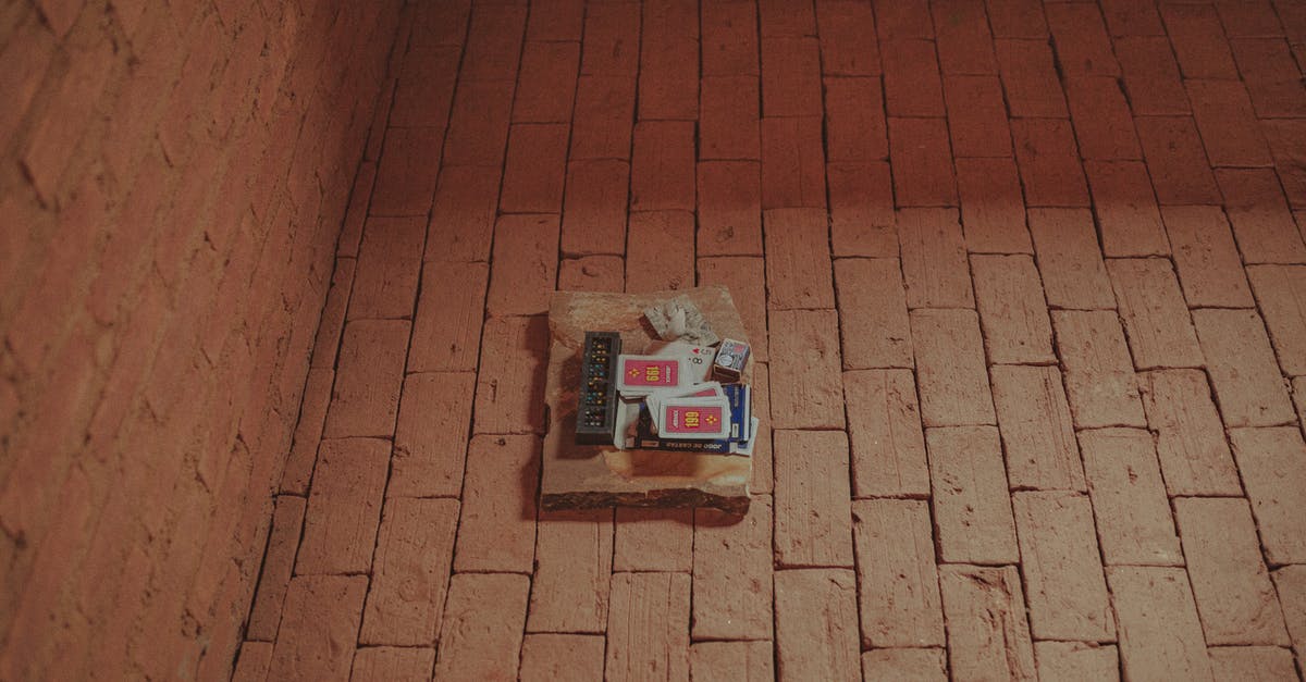 London: From Gatwick to the City with an Oyster Card [duplicate] - From above of domino and card decks placed together with matches on brick aged pavement